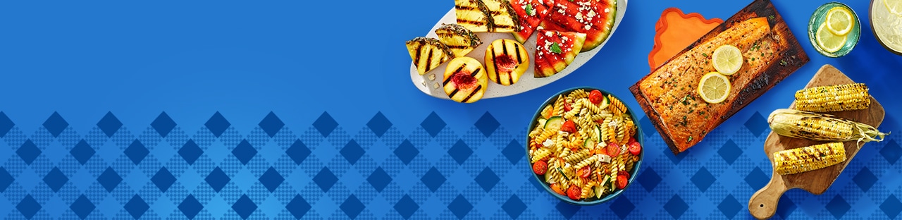 Image shows a grilled salmon with perfect char marks and grilled peaches and pineapple with watermelon on a blue background.