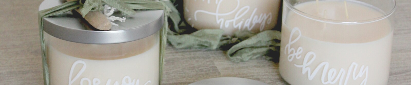 Close crop of white candles with silver lids and personalized messages written on the glass Close crop of white candles with silver lids and personalized messages written on the glass